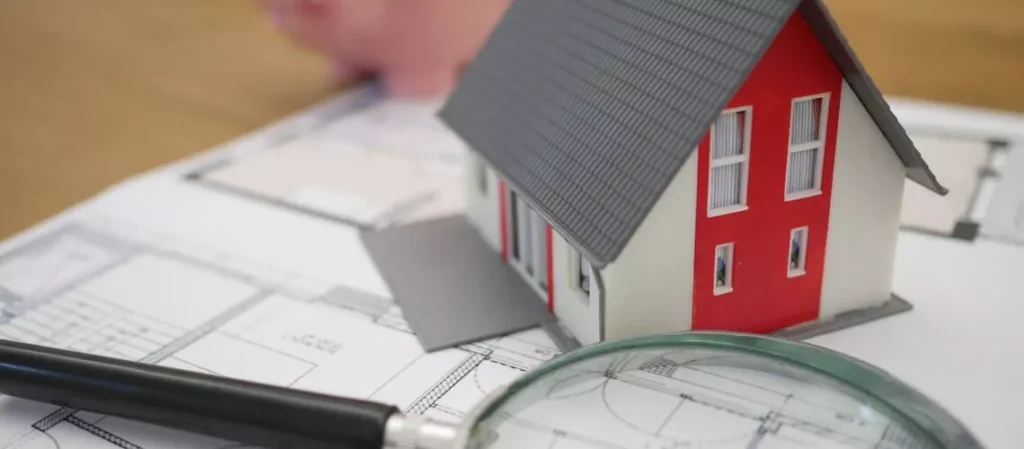 Magnifying glass over a house floor plan highlighting accuracy
